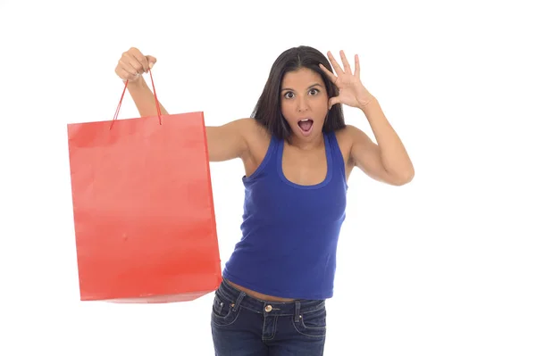 Young happy and beautiful hispanic woman holding red shopping bag smiling excited isolated on white — Stock Photo, Image