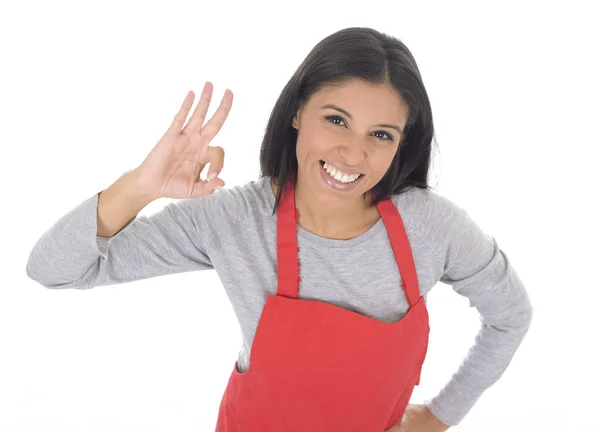 Ritratto aziendale di giovane attraente casa ispanica cuoca donna in grembiule rosso posa felice e sorridente isolato — Foto Stock