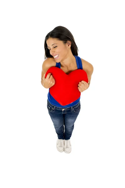 Jovem mulher bonita e feliz segurando vermelho almofada forma do coração sorrindo isolado em branco — Fotografia de Stock