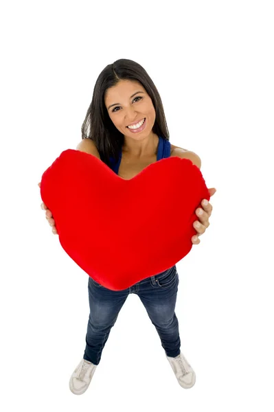 Giovane donna bella e felice con in mano cuscino rosso a forma di cuore sorridente isolato in bianco — Foto Stock