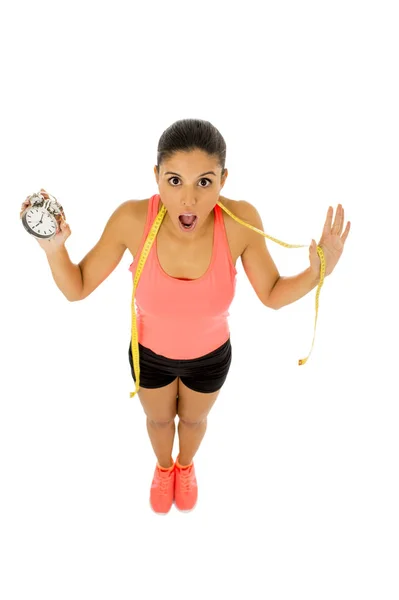 Mulher hispânica segurando despertador e taylor fita métrica a tempo para esporte e conceito de dieta — Fotografia de Stock