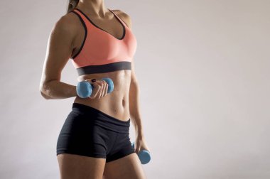 kırpılan vücut yakın çekim genç çekici kadın ağırlık dumbbell tutarak spor giyim