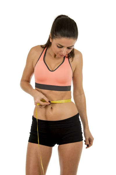 Jonge mooie sport vrouw in fitness kleding meten taille lichaamsgrootte holding maatregel tape — Stockfoto