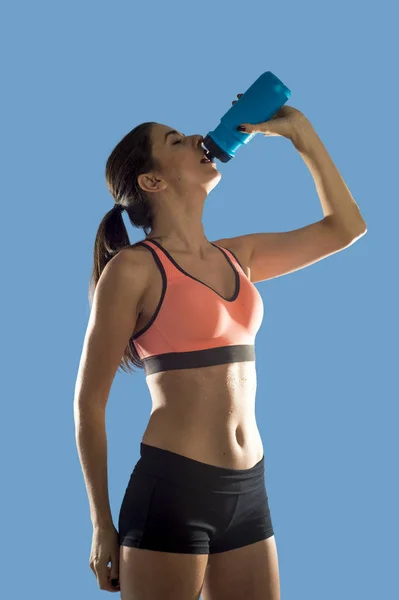 Bella e in forma donna sportiva in abiti fitness acqua potabile stanca durante l'allenamento — Foto Stock