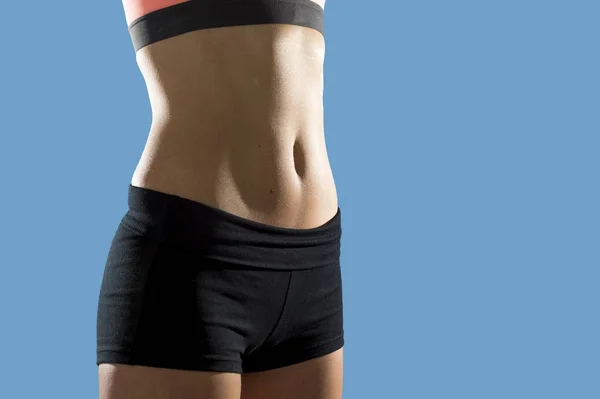 Mujer en forma con pantalones cortos y top deportivo mostrando delgado hermoso estómago y abdominales — Foto de Stock