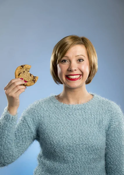 Roztomilá krásná žena s čokoládovou skvrny v ústech jíst velké lahodné cookie — Stock fotografie