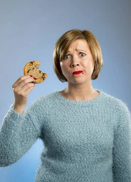 Cute beautiful woman with chocolate stain in mouth eating big delicious cookie — Stock Photo, Image