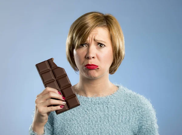 Žena držící tvářičky čokoláda s skvrny v ústech a vinu výraz v cukru závislost — Stock fotografie