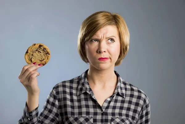 Mladá blond roztomilý a přátelské Kavkazský žena v neformálním oblečení drží velké lahodné čokolády cookie — Stock fotografie
