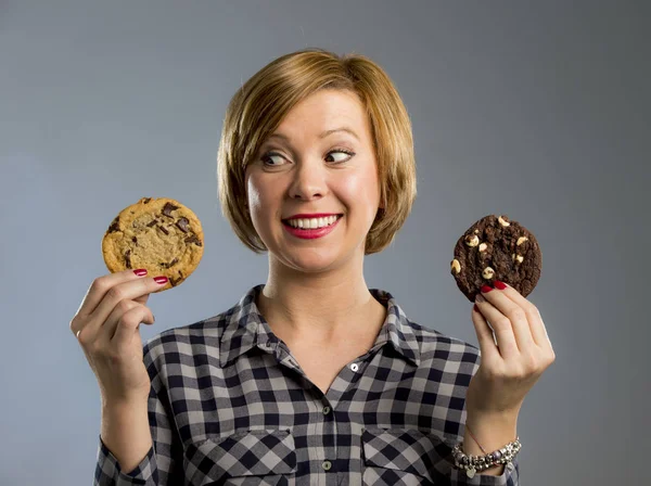 Jeune blonde mignonne et amicale femme caucasienne en vêtements décontractés tenant deux gros biscuits au chocolat — Photo