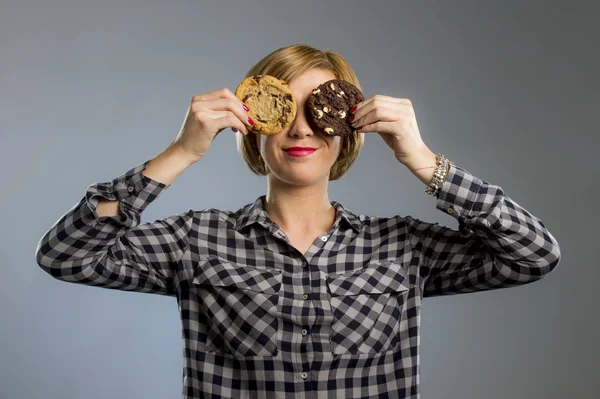 Mladá blond roztomilý a přátelské Kavkazský žena v neformálním oblečení drží dvě velké čokoládové cookies — Stock fotografie