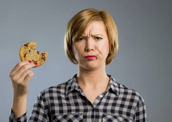 Cute beautiful woman with chocolate stain in mouth eating big delicious cookie — Stock Photo, Image