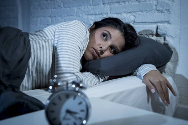 Mujer hispana en el dormitorio de casa acostada en la cama tarde en la noche tratando de dormir sufriendo insomnio — Foto de Stock