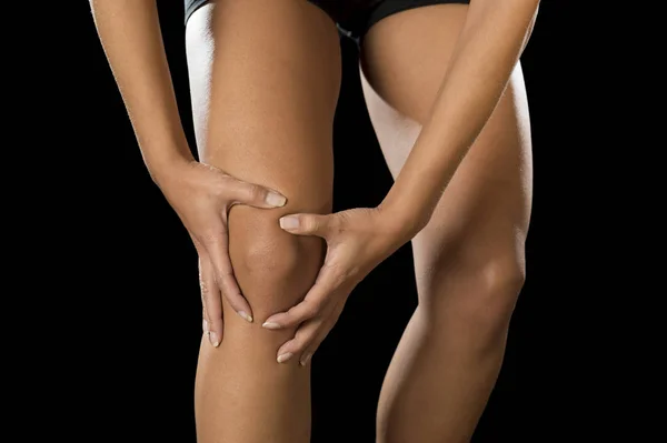 Mladý sportovní žena držící zraněné koleno trpí bolesti zranění vazů nebo vytáhl sval — Stock fotografie
