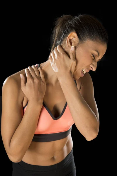 Mujer de fitness hispana tocándose y agarrándose el cuello y la parte superior de la espalda sufriendo dolor cervical — Foto de Stock