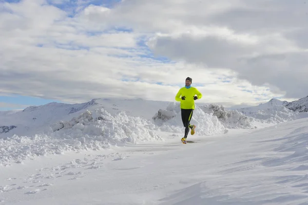 Jeune homme de sport en bonne santé courir dans les montagnes de neige en traînard entraînement dur en hiver — Photo