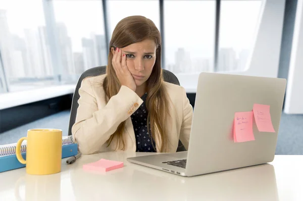 Mulher estressada trabalhando com computador portátil na mesa em excesso de trabalho — Fotografia de Stock