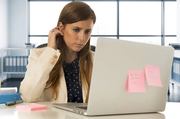 Stressad kvinna som arbetar med bärbar dator på skrivbord i överarbetad — Stockfoto