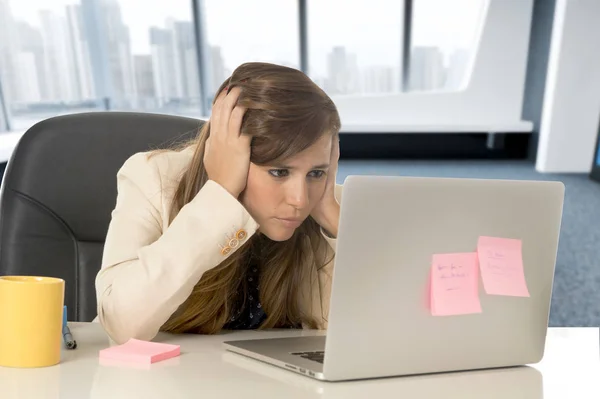 Stressad kvinna som arbetar med bärbar dator på skrivbord i överarbetad — Stockfoto