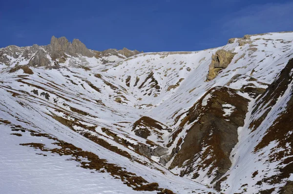 Vista panorámica de las montañas de nieve y la estación de esquí en Suiza Europa en un día soleado frío — Foto de Stock