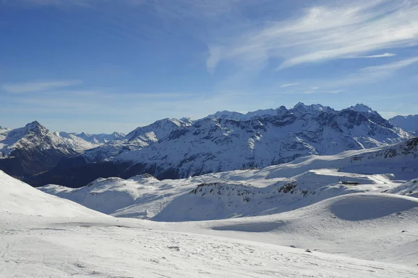 Vista panorámica de las montañas de nieve y la estación de esquí en Suiza Europa en un día soleado frío — Foto de Stock