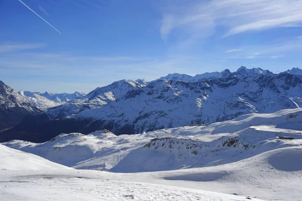 Vista panorámica de las montañas de nieve y la estación de esquí en Suiza Europa en un día soleado frío — Foto de Stock