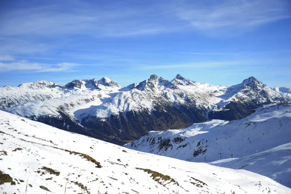 Vista panorámica de las montañas de nieve y la estación de esquí en Suiza Europa en un día soleado frío — Foto de Stock