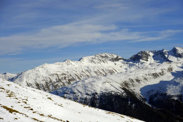 Vista panorámica de las montañas de nieve y la estación de esquí en Suiza Europa en un día soleado frío — Foto de Stock