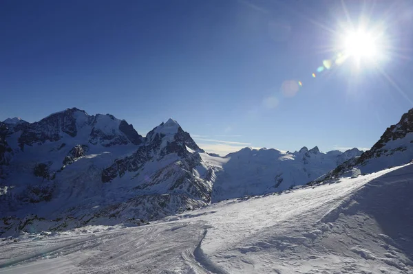 Vista de las montañas de nieve y la pista de esquí en Suiza Europa en un día frío y soleado — Foto de Stock