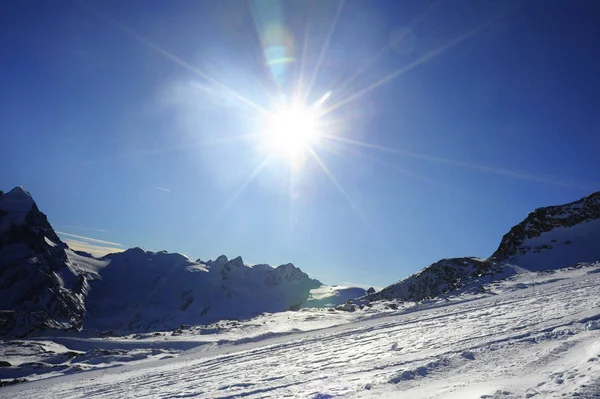 Vista de las montañas de nieve y la pista de esquí en Suiza Europa en un día frío y soleado — Foto de Stock