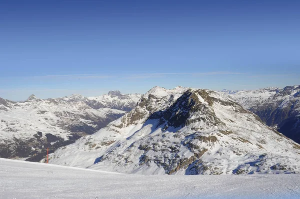 Vista de las montañas de nieve y la pista de esquí en Suiza Europa en un día frío y soleado — Foto de Stock