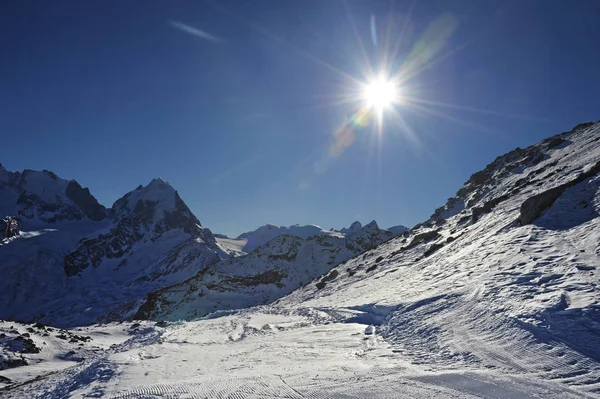 Vista de las montañas de nieve y la pista de esquí en Suiza Europa en un día frío y soleado — Foto de Stock