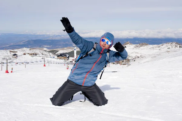 冬の風景に雪山のピーク山頂トレッキング達成後勝利のサインをしている男性 — ストック写真