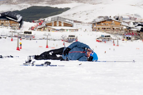 Homem deitado na neve fria após acidente de esqui em Sierra Nevada resort na Espanha com montanhas — Fotografia de Stock