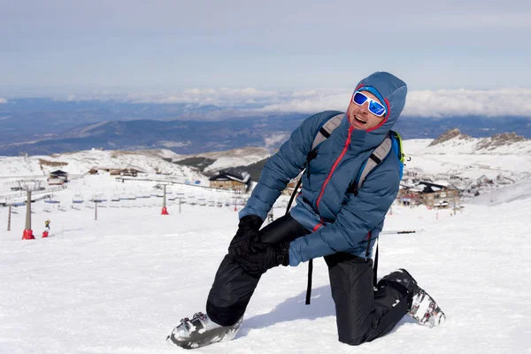 Homme couché sur la neige froide après l'accident de ski tenant son genou blessé dans la douleur à la station Sierrna Nevada — Photo