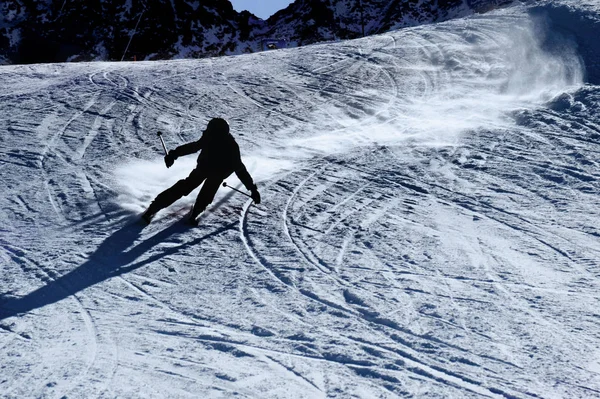 Silhouette rétroéclairée de l'homme en action pratiquant le ski en descendant rapidement et agressivement la pente de neige sport d'hiver — Photo