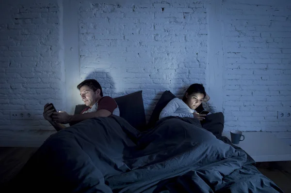 Paar thuis in bed laat in de avond gebruik mobiele telefoon in relatie communicatieprobleem — Stockfoto