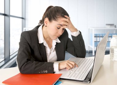 modern ofis odasında dizüstü bilgisayar üzerinde çalışan takım elbise giyen işkadını