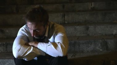 4k video takım elbise ve kravat acı stres ve drepression gece üzgün ve endişeli kriz durgunluk kavramı kentsel sokak merdiven üzerinde oturan genç umutsuz işadamı kaydırma 24 fps lateral görüntü