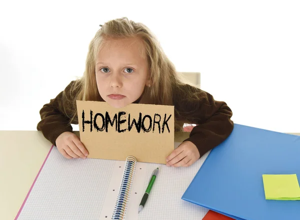 Ung vacker liten skolflicka ledsen och överväldigad håller papper med text läxor — Stockfoto