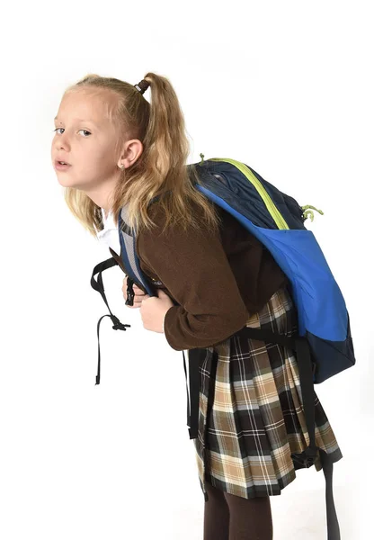 Krásná malá školačka unavený a vyčerpaný, nesoucí na její zadní těžký školní batoh pohledu smutný — Stock fotografie