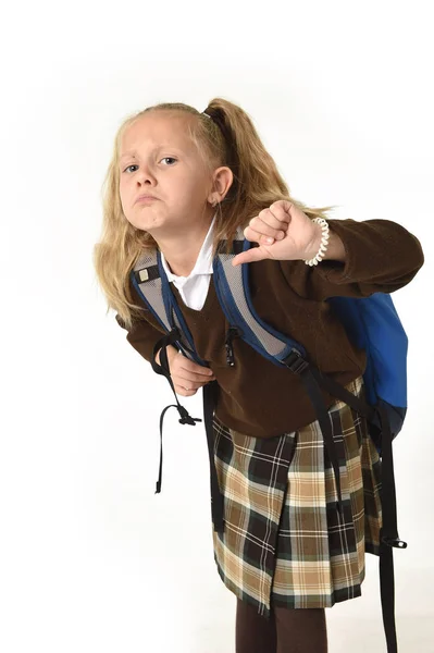 Vacker liten skolflicka trött och utmattad bär på hennes tillbaka tunga skolan ryggsäck ser ledsen — Stockfoto