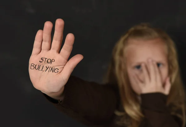 Linda colegiala asustada triste pidiendo ayuda mostrando las manos con dejar de intimidar texto escrito en su palma — Foto de Stock