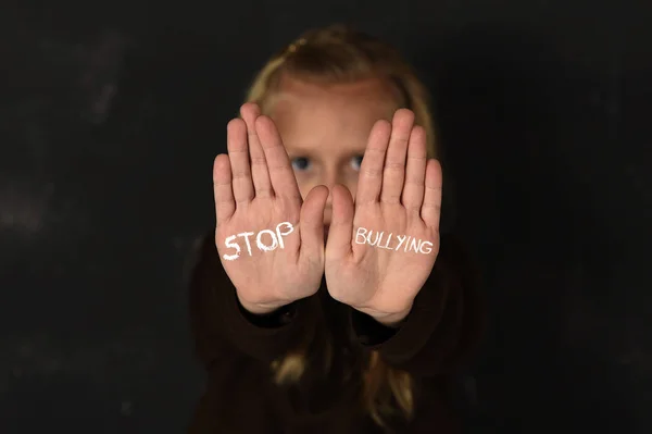 Carino studentessa spaventato triste chiedendo aiuto mostrando le mani con smettere di bullismo testo scritto sul suo palmo — Foto Stock