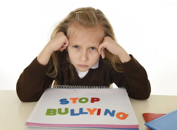 Depressief jong schoolmeisje met stop pesten tekst op notebook hulpeloos en bang als slachtoffer van pesten — Stockfoto