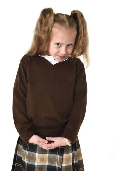 Pequeña colegiala con hermoso pelo rubio en uniforme escolar buscando tímido y tímido — Foto de Stock