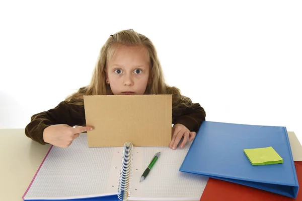 Malá školačka smutný unavený a znuděný, drží papír s prázdnou kopii prostor pro přidání textu — Stock fotografie