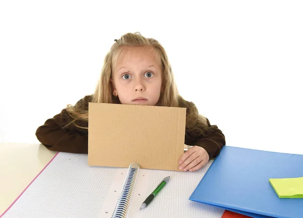 Malá školačka smutný unavený a znuděný, drží papír s prázdnou kopii prostor pro přidání textu — Stock fotografie