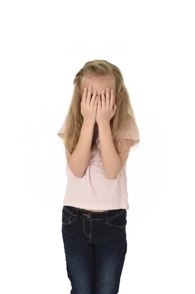 Sweet young little schoolgirl covering her face with her hands crying sad victim of bullying at school — Stock Photo, Image