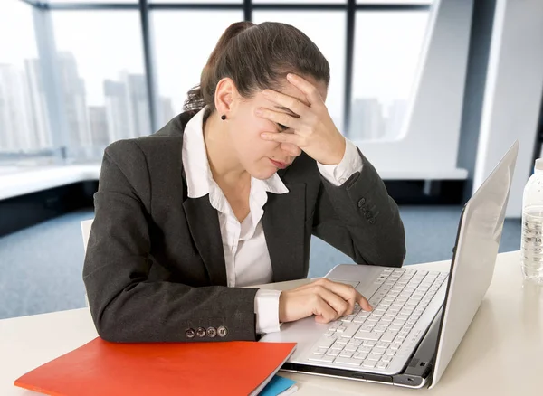 Femme d'affaires surmenée portant un costume d'affaires tenant sa main sur son visage travaillant sur ordinateur — Photo